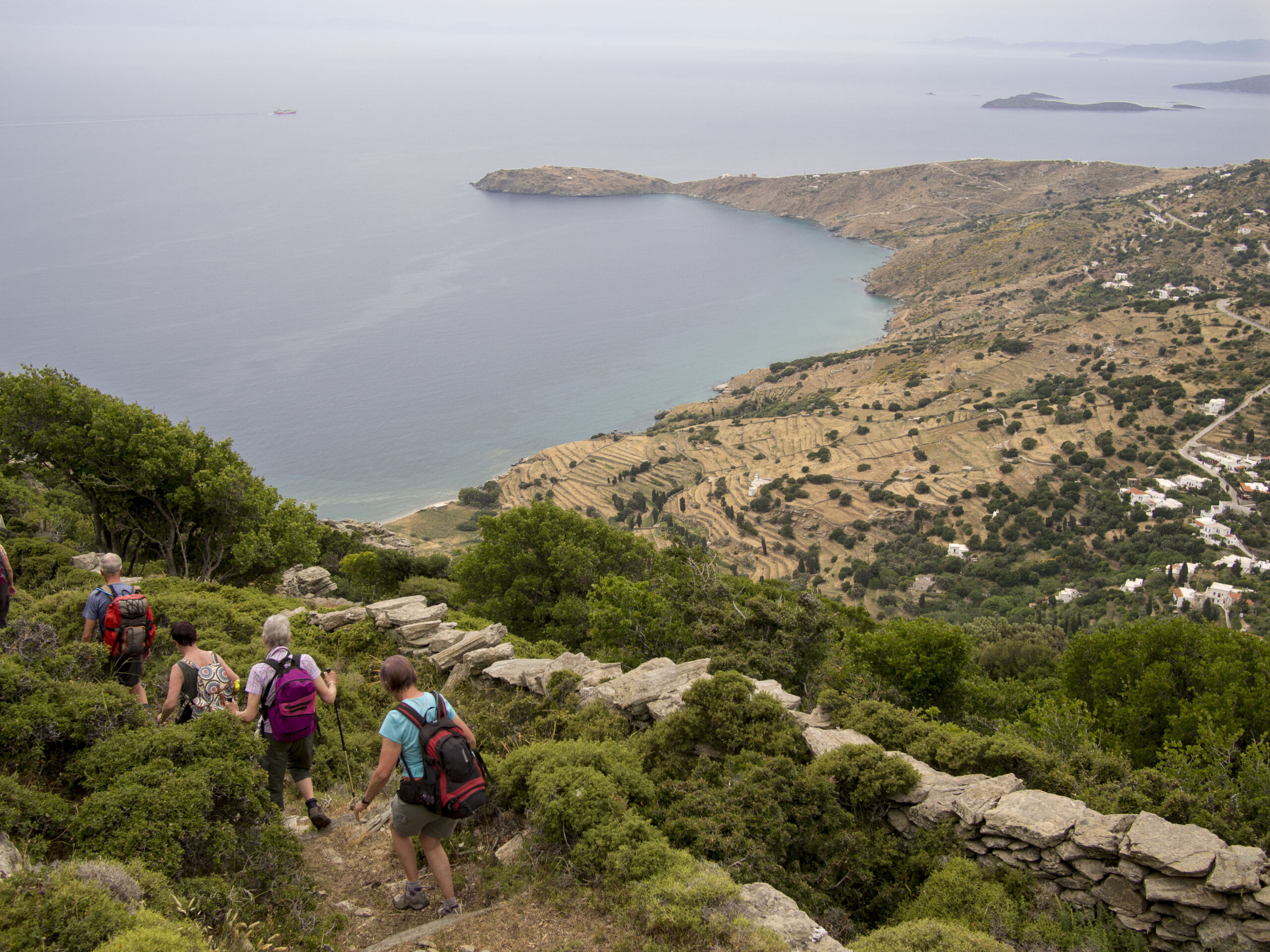 Hikers descending a coastal hillside of the Paleopolis circular route.